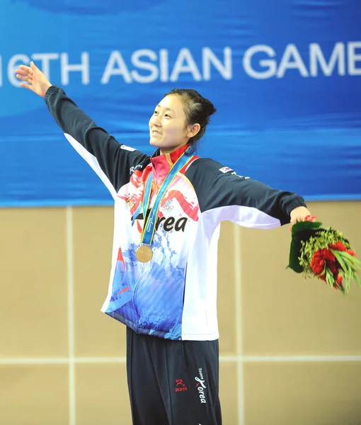 2010年11月18日 在第十六届亚运会广东省广州市举行的第十六届亚运会女子57公斤以上级决赛中 韩国的李成惠在领奖台上庆祝她的金牌 — 图库照片