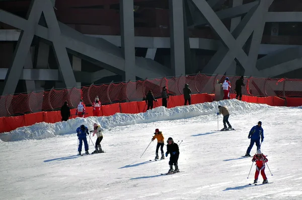 中国の住民は 2009年12月30日 中国の北京で 鳥の巣として知られている国立競技場の外のスキーリゾートでスキーを楽しむ — ストック写真