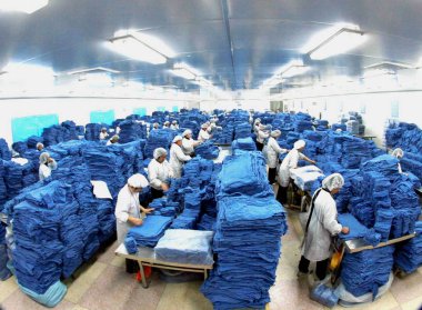 Female Chinese factory workers manufacture clothes to be exported at a garment plant in Haian, east Chinas Jiangsu province 5 March 2008 clipart