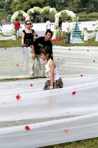 부부의 친구는 신부의 꼬리를 2162 길이의 드레스는 공원에서 결혼식 2009 — 스톡 사진