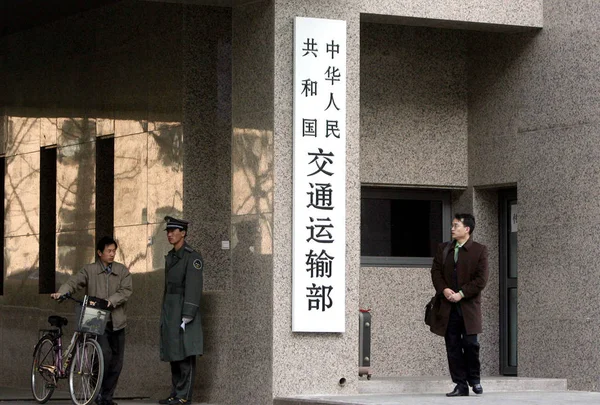 2008年3月24日 在新成立的北京交通部门口 当地的中国人在一名保安人员的陪同下行走 — 图库照片