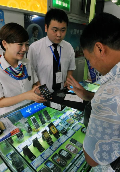 ファイル 営業マンとセールスマンは 2009年7月7日 中国南西部四川省成都の店で顧客3G携帯電話を紹介します — ストック写真