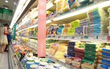 A customer shopping for cheese and other dairy products at a supermarket in Shanghai 1 August 2007. clipart