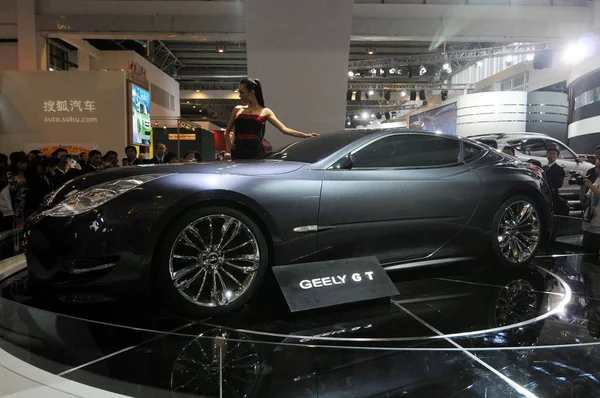 2008年4月20日 在中国北京举行的2008年中国汽车车展上 游客们观看了一个与吉利 概念跑车摆姿势的模型 — 图库照片