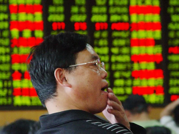 Ein Chinesischer Investor Vor Einem Tisch Mit Den Aktienkursen Rot — Stockfoto