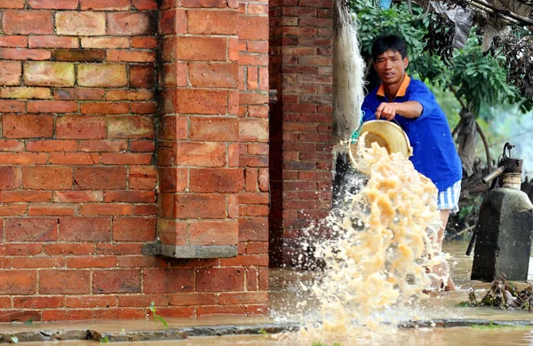 2008年6月17日 中国广东省佛山市一个村庄 一名中国村民从他家的房子里倾泻洪水 — 图库照片