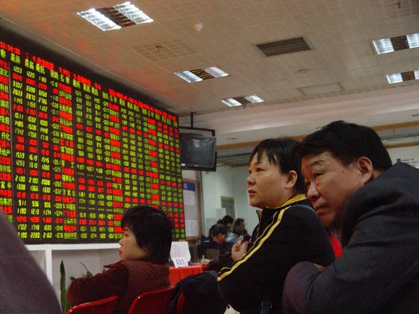 2008年1月16日 在中国南方海南省海口的一家证券交易所大厅 中国投资者看了显示上证综指实时信息 价格上涨为红色 价格下跌为绿色 的大屏幕 — 图库照片