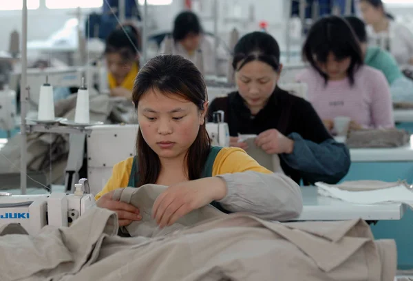 中国の女性工場労働者が 東中国江蘇省にある南通市の縫製工場で衣服を作る 月2006 — ストック写真