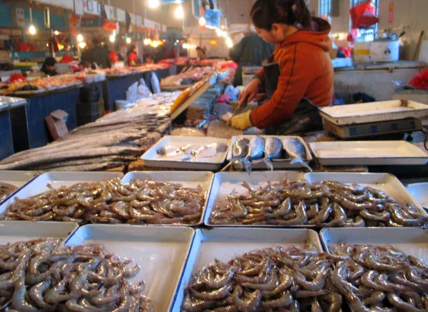 2006年11月28日 一名中国小贩在北京的一家食品市场销售虾和其他海鲜 — 图库照片