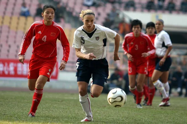 2007年1月30日 在广东省广州广东奥林匹克体育场举行的中国和 四国足球比赛中 中国的温新志身穿红色衣服 与美国选手林赛 塔普利争夺皮球 — 图库照片