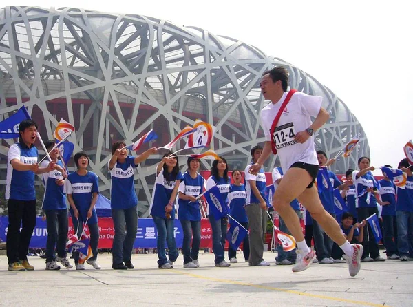 2008年4月30日 在北京夏季奥运会举行的为期100天的倒计时庆祝活动中 一名跑步者在一次弥撒中跑过国家体育场 — 图库照片