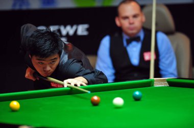Chinas Ding Junhui (F) aims while Englands Stuart Bingham looks on during second round of the Shanghai Masters Snooker Tournament 2009 in Shanghai, China, Thursday, September 10, 2009 clipart