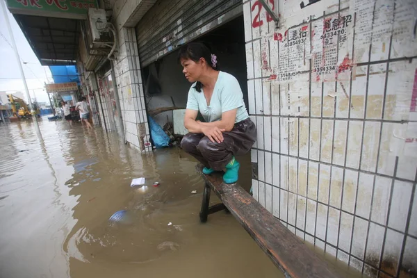 2008年6月13日 在广东省深圳市 一名妇女在大雨引发的洪水中蹲在长凳上 — 图库照片