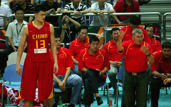 中国国家篮球队前右教练乔纳斯 卡兹劳斯卡斯在中国东部的南京市2008年国际钻石杯男装篮球比赛中 在与澳大利亚的篮球比赛中 左起姚明在看着姚明的指示 — 图库照片