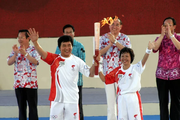 2008年5月4日 好莱坞功夫巨星成龙 和当地镇长浦惠芳 在中国海南省三亚市举行的2008年奥运会火炬传递仪式上举行奥运火炬传递 — 图库照片