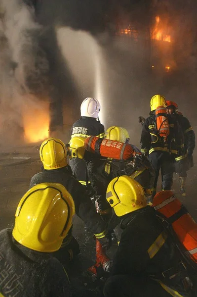 2008년 북서부 위구르 자치구 우루무치에서 화재가 발생한 시장을 소방관들이 호스를 — 스톡 사진