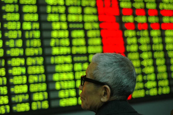2009年11月24日星期二 在中国上海的一家经纪房 一位中国投资者看股价 价格上涨为红色 价格下跌为绿色 — 图库照片