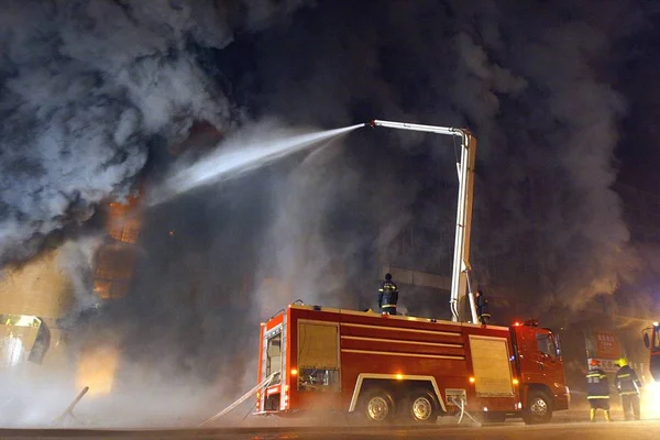 2008년 북서부 위구르 자치구 우루무치에서 화재가 발생한 시장을 소방관들이 호스를 — 스톡 사진