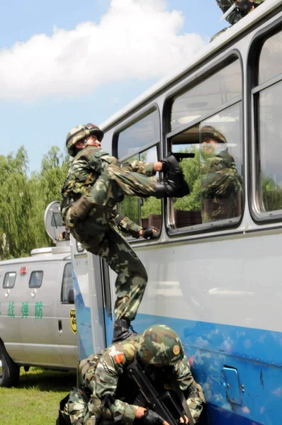 中国の準軍事警官は 2008年7月7日 中国北東部黒龍江省ハルビン市での反テロ訓練中にテロリストと戦うためにバスに侵入した — ストック写真