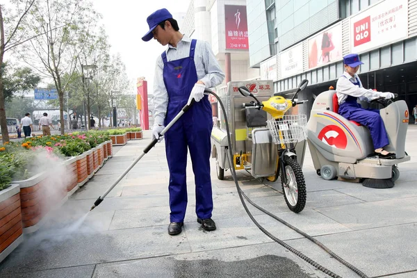 Chinese Cleaning Worker Sprays Water Clear Away Ads Ground Street — 스톡 사진
