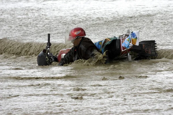 オートバイの運転手は Hoboksar モンゴル自治郡の高速道路で大雨の後洪水によってノックダウンされます 北西中国新疆ウイグル自治区 月2007 — ストック写真