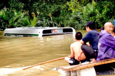 Chinese local residents look at a bus submerged by floods on the street in Liuzhou, south Chinas Guangxi Zhuang Autonomous Region 13 June 2007 clipart