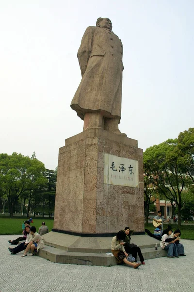 ファイル 未公開の写真は 上海の復旦大学のキャンパスで毛沢東の像の周りに座っている中国人学生を示しています — ストック写真