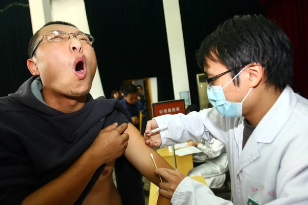 Chiński Pracownik Medyczny Wstrzykuje Kierowca Autobusu Szczepionką Przeciw Grypie H1N1 — Zdjęcie stockowe