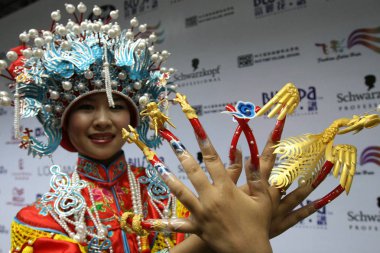 A traditionally-dressed model shows her nails during a beauty contest in Beijing 19 July 2007. clipart
