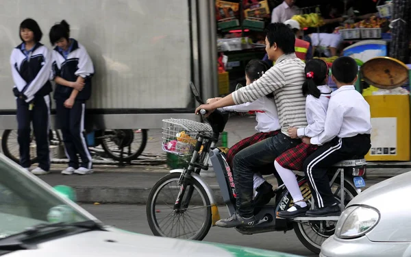 Hombre Chino Monta Bicicleta Eléctrica Llevando Tres Alumnos Una Calle — Foto de Stock