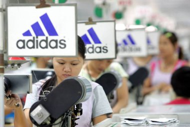 Chinese factory workers make Adidas shoes at the factory of Yue Yuen Industrial (Holdings) Limited in Dongguan city, south Chinas Guangdong province, September 20, 2005. clipart