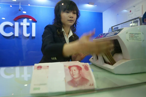 A Chinese bank clerk counts RMB banknotes at the Lujiazui subbranch of Citi Shanghai Branch in Lujiazui Financial District in Pudong, Shanghai 23 April 2007.