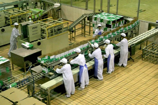 中国の工場労働者は Luannan 市の蒙グループの酪農工場で生産ラインに蒙ミルクをパックします 北中国河北省 月2007 — ストック写真