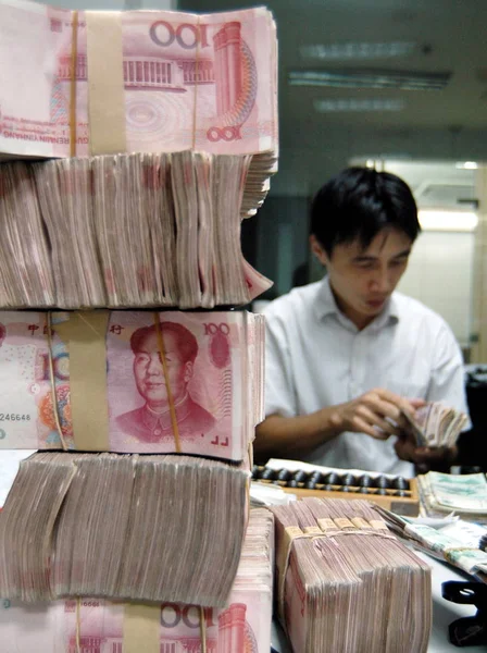 A Chinese bank clerk counts RMB (Renminbi) banknotes at a branch of China Construction Bank (CCB) in Haian county, east Chinas Jiangsu province, 25 September 2008