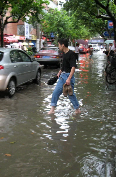 Człowiek Jego Buty Rękach Spacery Powodzi Spowodowane Przez Ciężki Deszcz — Zdjęcie stockowe