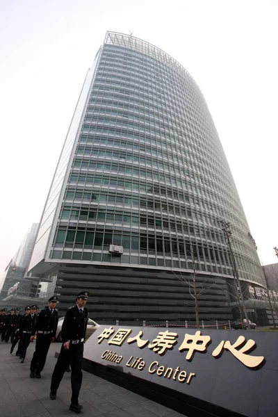 中国の警備員は 2008年3月22日 中国の北京にある中国生命保険 Group 会社の本部である中国生命センターを通り過ぎる — ストック写真