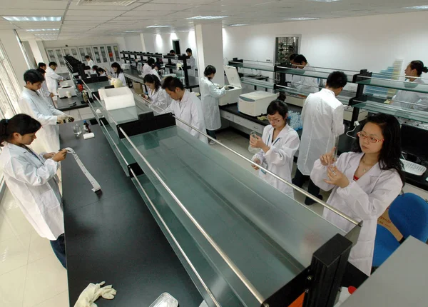 中国の研究者は 2007年9月21日 中国東部江蘇省台州市の復旦保健技術研究所 Cmc の研究室で 地元住民から採取した唾液のサンプルに取り組んでいます — ストック写真