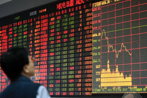 2007年10月18日 一位中国投资者在上海一家股票经纪公司看了一个显示股价的屏幕 — 图库照片