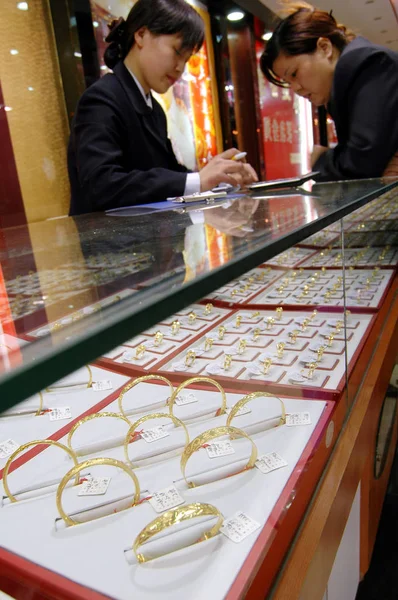 ファイル 中国のセールスウーマンは 顧客が2006年4月20日に中国東部江蘇省海安市の金店で金の装飾品を購入するのを助けます — ストック写真