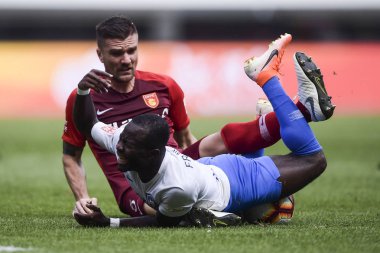 Hong Kong football player Andy Russell, left, of Hebei China Fortune challenges Ghanaian football player Frank Opoku Acheampong of Tianjin TEDA in their 10th round match during the 2019 Chinese Football Association Super League (CSL) in Tianjin, Chin
