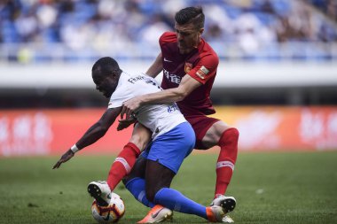 Hong Kong football player Andy Russell, right, of Hebei China Fortune challenges Ghanaian football player Frank Opoku Acheampong of Tianjin TEDA in their 10th round match during the 2019 Chinese Football Association Super League (CSL) in Tianjin, Chi