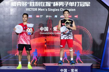 Japanese professional badminton player Kento Momota, right, and Indonesian professional badminton player Anthony Sinisuka Ginting, left, are at the awarding ceremony of men's single of VICTOR China Open 2019, in Changzhou city, east China's Jiangsu p clipart