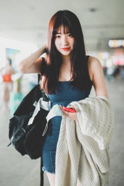 Huang Yiming, a girl who participated into Chinese reality show Youth with You Season 2, alternatively known as Idol Producer Season 3, shows up with girly smile in blue dress and black boots at an airport in Chengdu city, southwest China's Sichuan p clipart