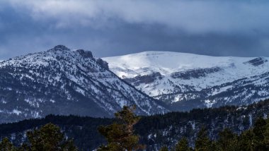 Karla kaplı dağlar ve güneş ışınları ile manzara.