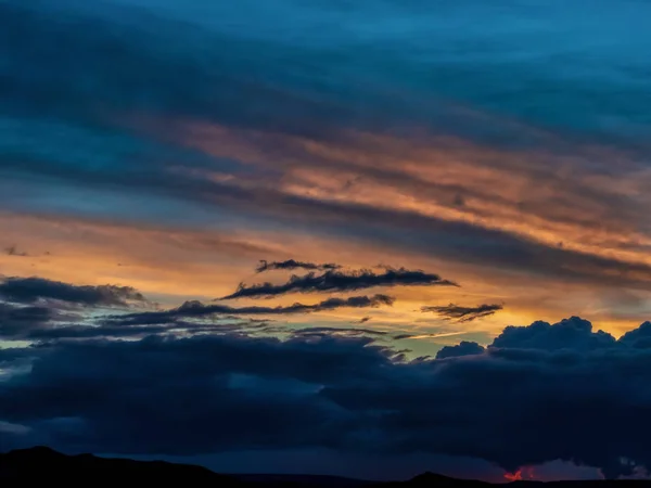 Frühlingssonnenuntergang mit Regenwolken und Bergen im Hintergrund — Stockfoto