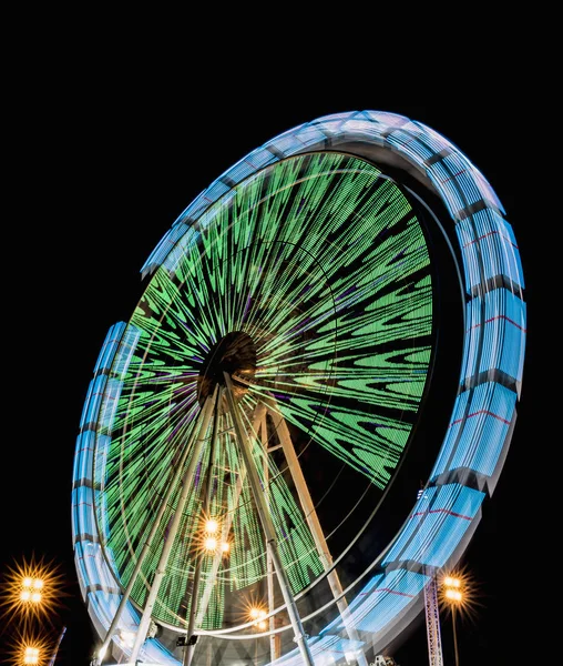 Draaiende reuzenrad 's nachts in een park van afleidingen met prachtige kleuren — Stockfoto