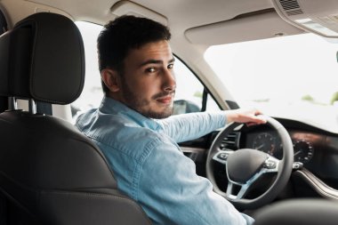 Güzel bir araba süren yakışıklı bir adam.