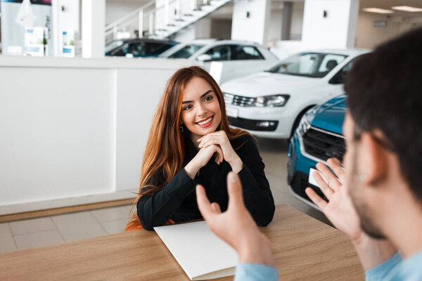 Car salesman explains the terms of a deal to a client who buys a car