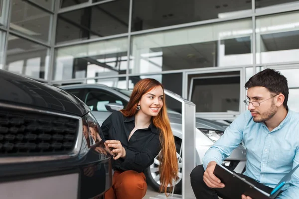 Vendedor Mostra Carro Jovem Cliente Uma Concessionária Automóveis Menina Escolhe — Fotografia de Stock