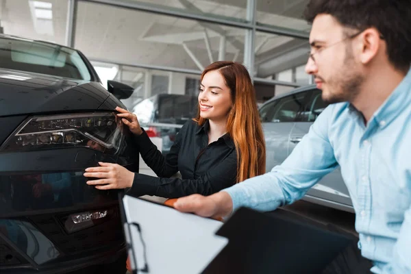 Vendedor Mostra Carro Jovem Cliente Uma Concessionária Automóveis Menina Escolhe — Fotografia de Stock